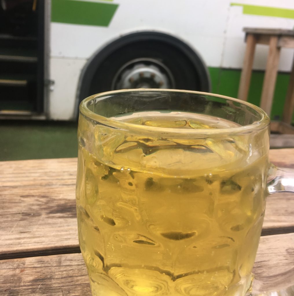 A fresh cider sitting outside at Preachers (pub), which has a decommissioned Metro bus as part of the outdoor area